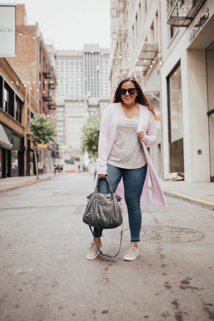 Ashley from Two Peas in a Prada shares layering tips for summer featuring Good American jeans and a Free People ribbed cardigan.