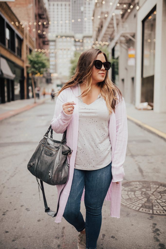 Ashley from Two Peas in a Prada shares layering tips for summer featuring Good American jeans and a Free People ribbed cardigan.
