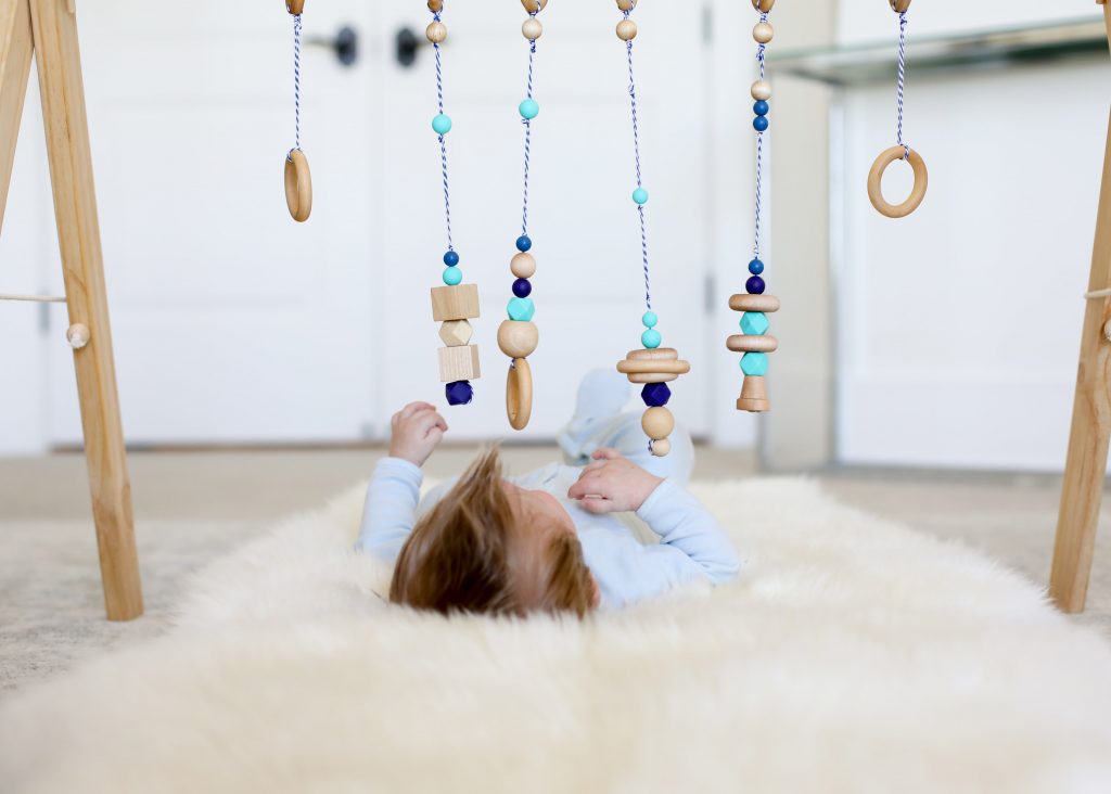 Emily Farren Wieczorek of Two Peas in a Prada plays with her infant son under a BoandRoo natural wooden baby gym and talks about the best new baby products of 2017.