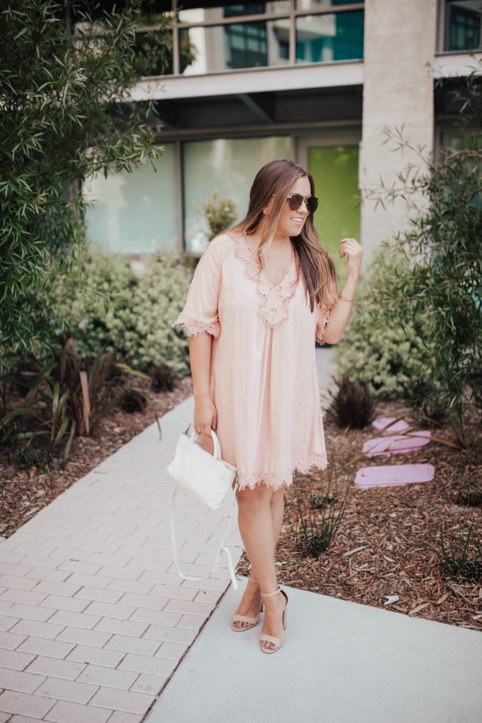 Ashley Zeal from Two Peas in a Prada shares a long sleeved pink dress with lace detail for under $50 and many similar items. 