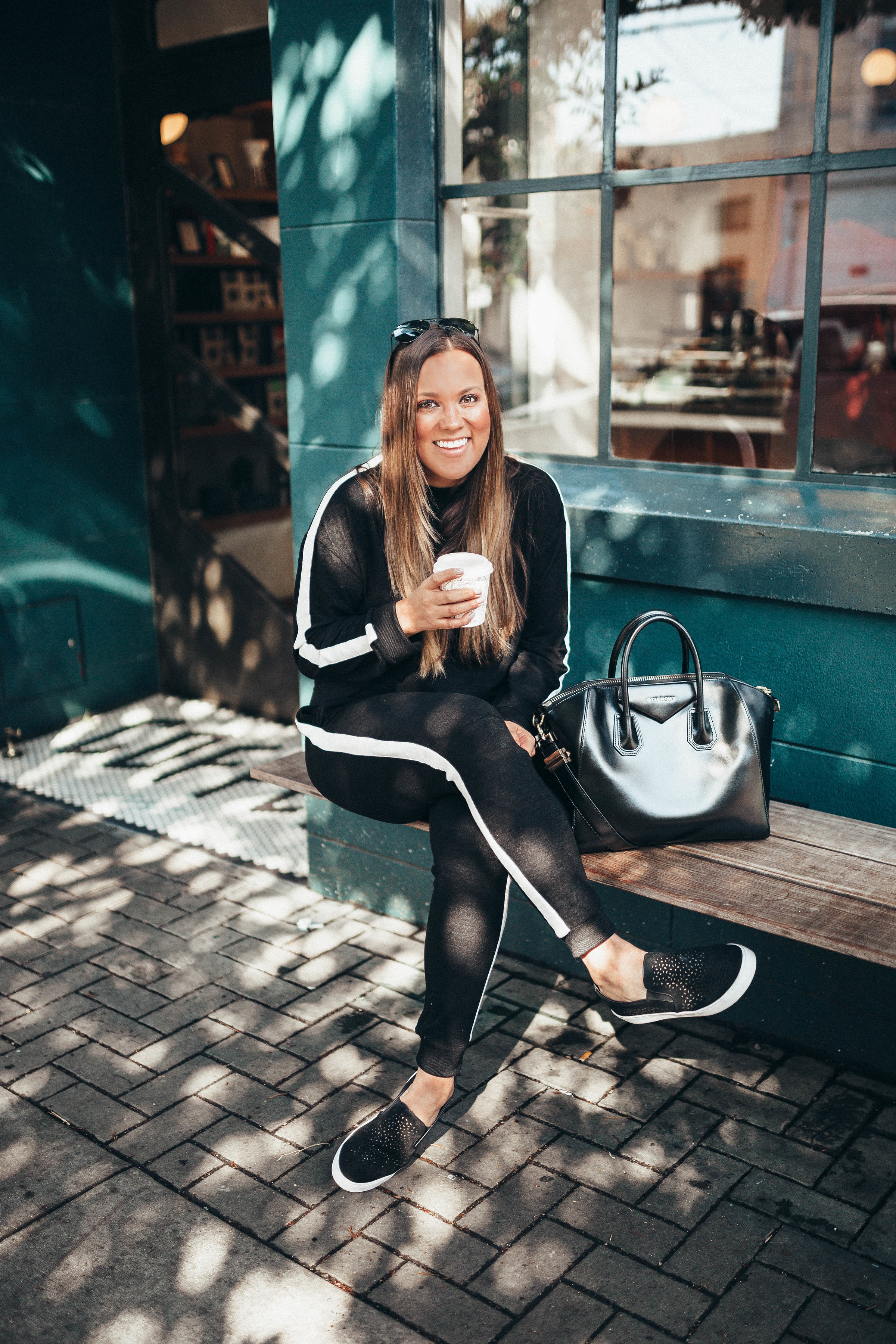 Ashley Zeal from Two Peas in a Prada shares her Friday OOTD which is a tracksuit under $80, perforated sneakers and a Givenchy available from Nordstrom! 