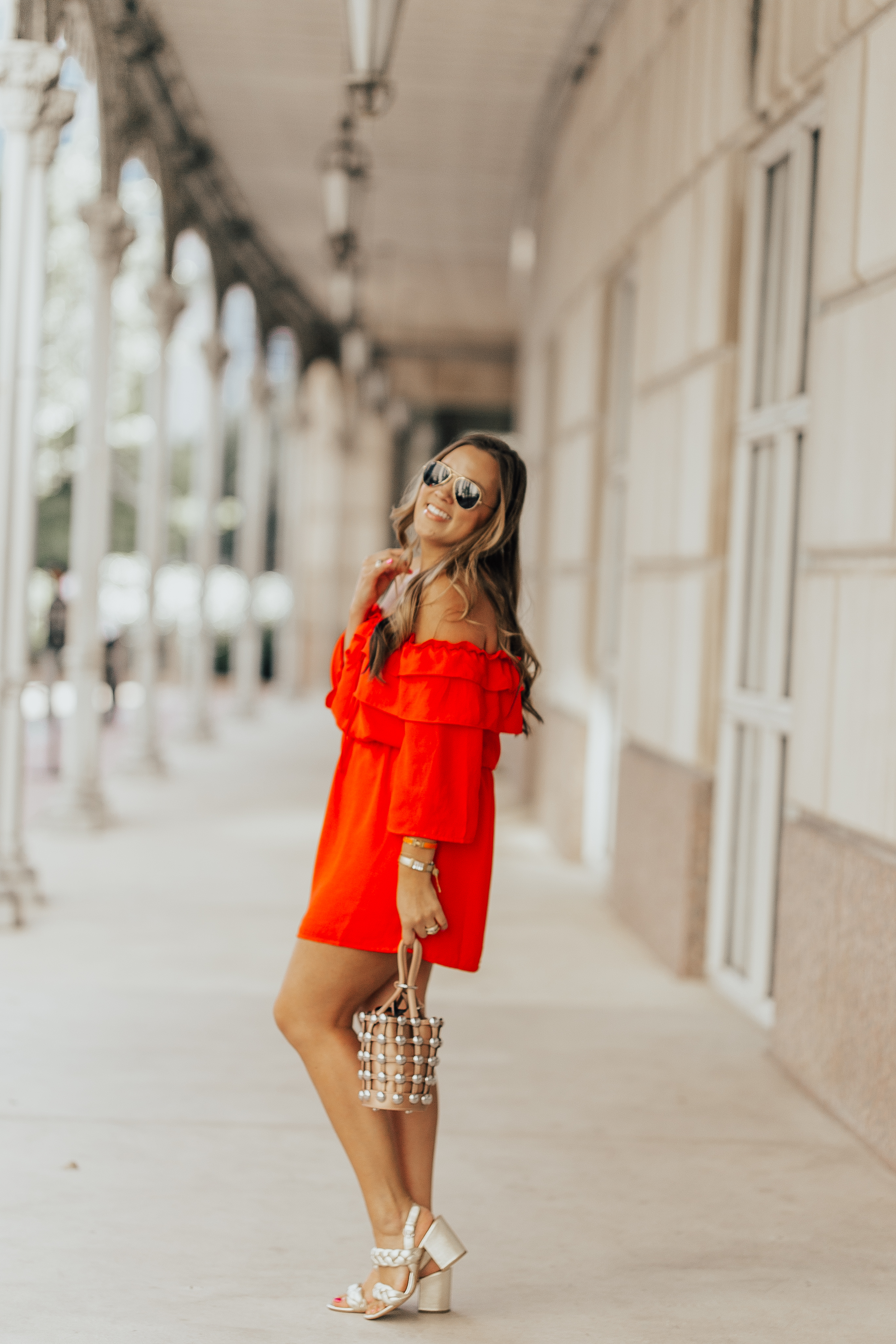 Ashley Zeal from Two Peas in a Prada shares a bright orange off the shoulder dress. She is wearing Rebecca Minkoff heels, and an Alexander Wang bag.