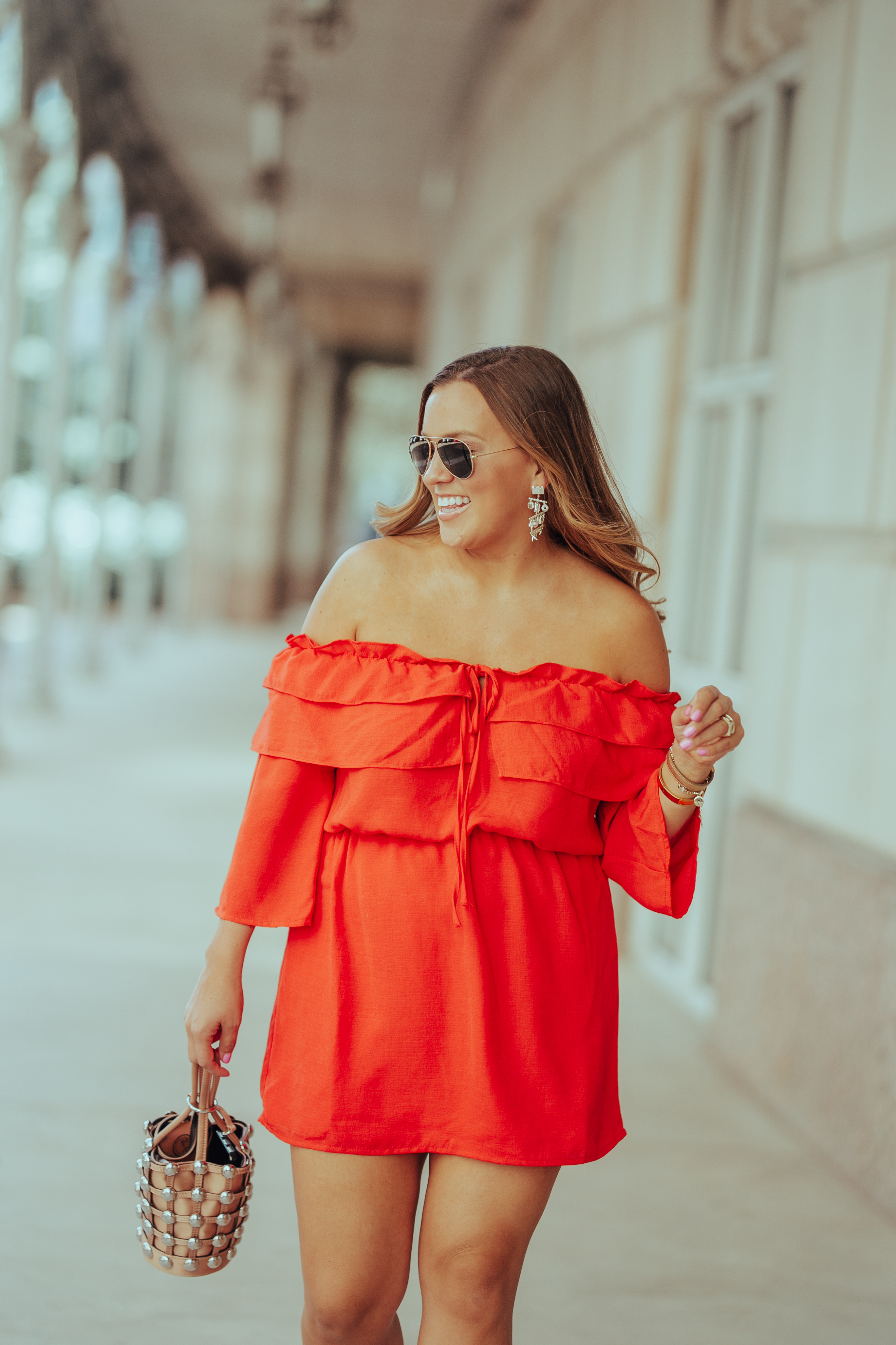 Ashley Zeal from Two Peas in a Prada shares a bright orange off the shoulder dress. She is wearing Rebecca Minkoff heels, and an Alexander Wang bag. 