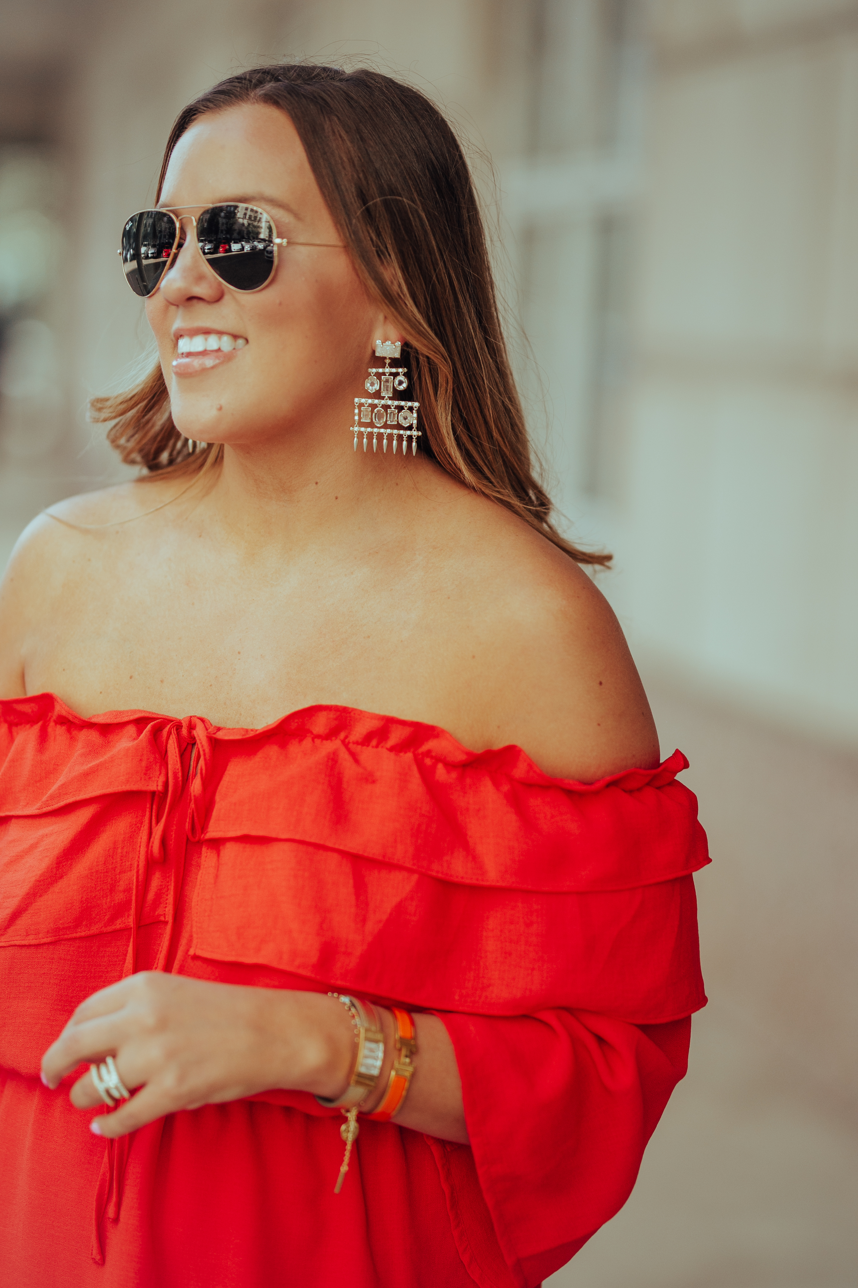 Ashley Zeal from Two Peas in a Prada shares a bright orange off the shoulder dress. She is wearing Rebecca Minkoff heels, and an Alexander Wang bag. 