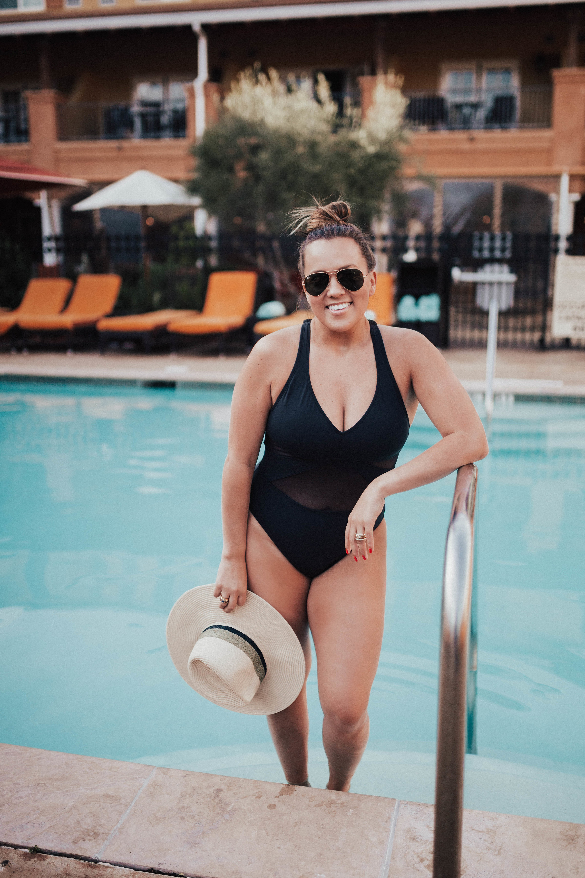 Ashley Zeal from Two Peas in a Prada shares what's in her beach bag, including: sunscreen, lip balm, sunnies and sun hats! She is wearing Bleu by Rod Beattie. 