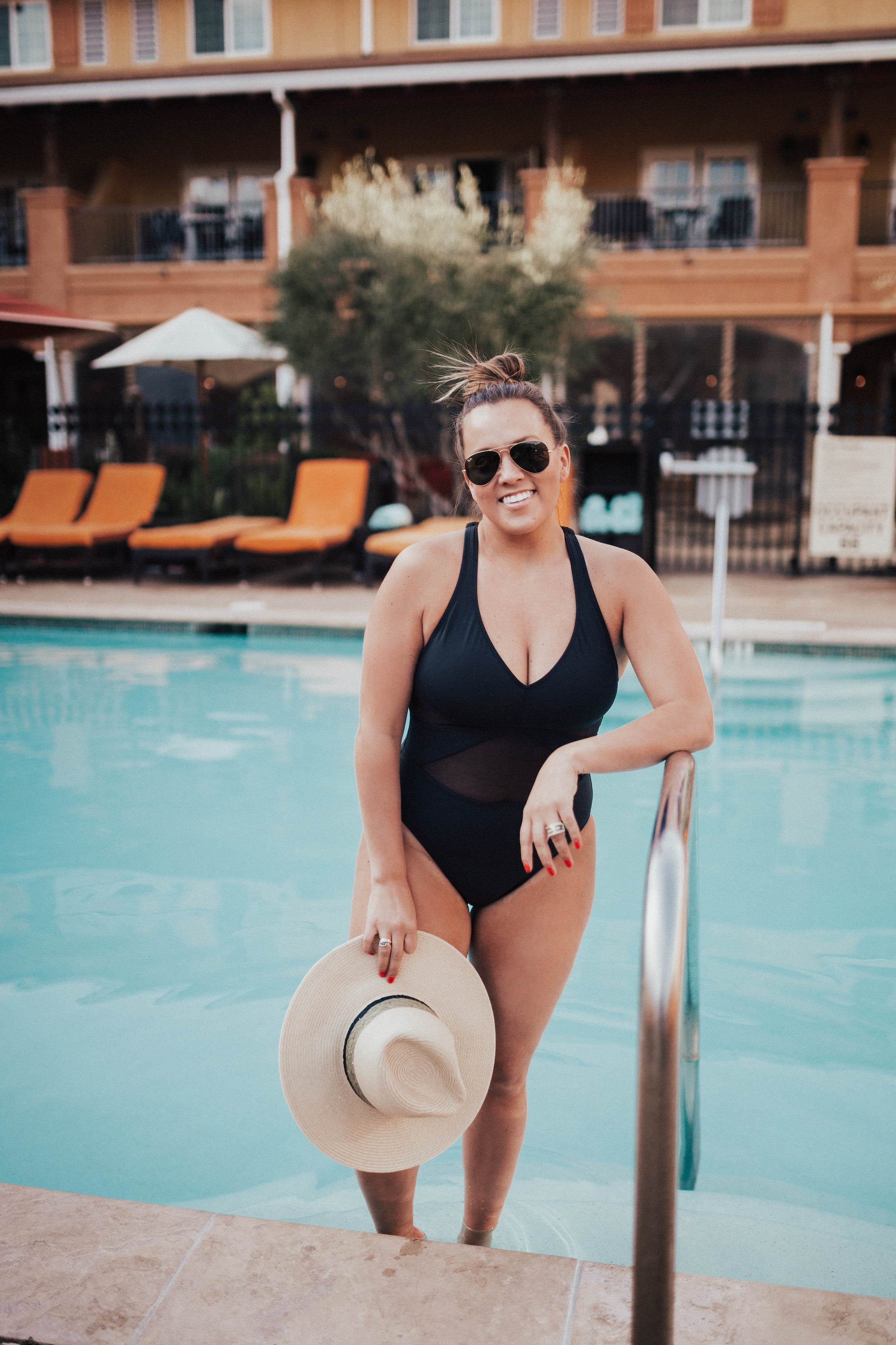 Ashley Zeal from Two Peas in a Prada shares what's in her beach bag, including: sunscreen, lip balm, sunnies and sun hats! She is wearing Bleu by Rod Beattie. 