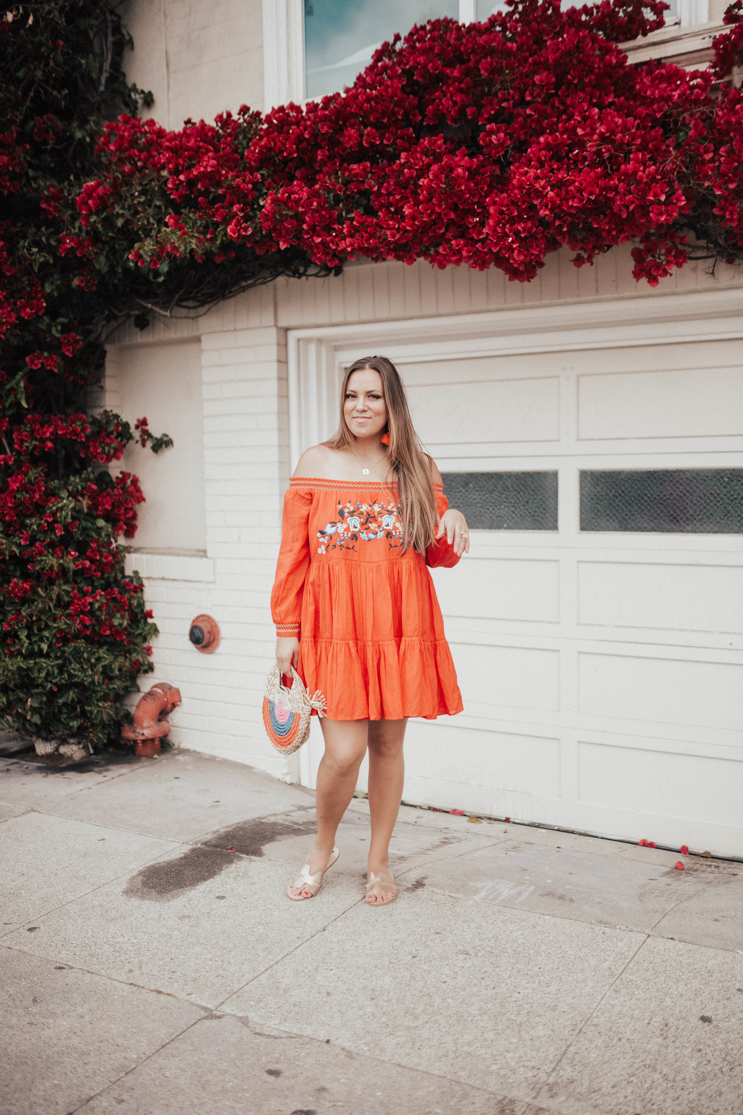 Ashley Zeal from Two Peas in a Prada wears an orange off the shoulder Free People dress and shares the best summer dresses. 