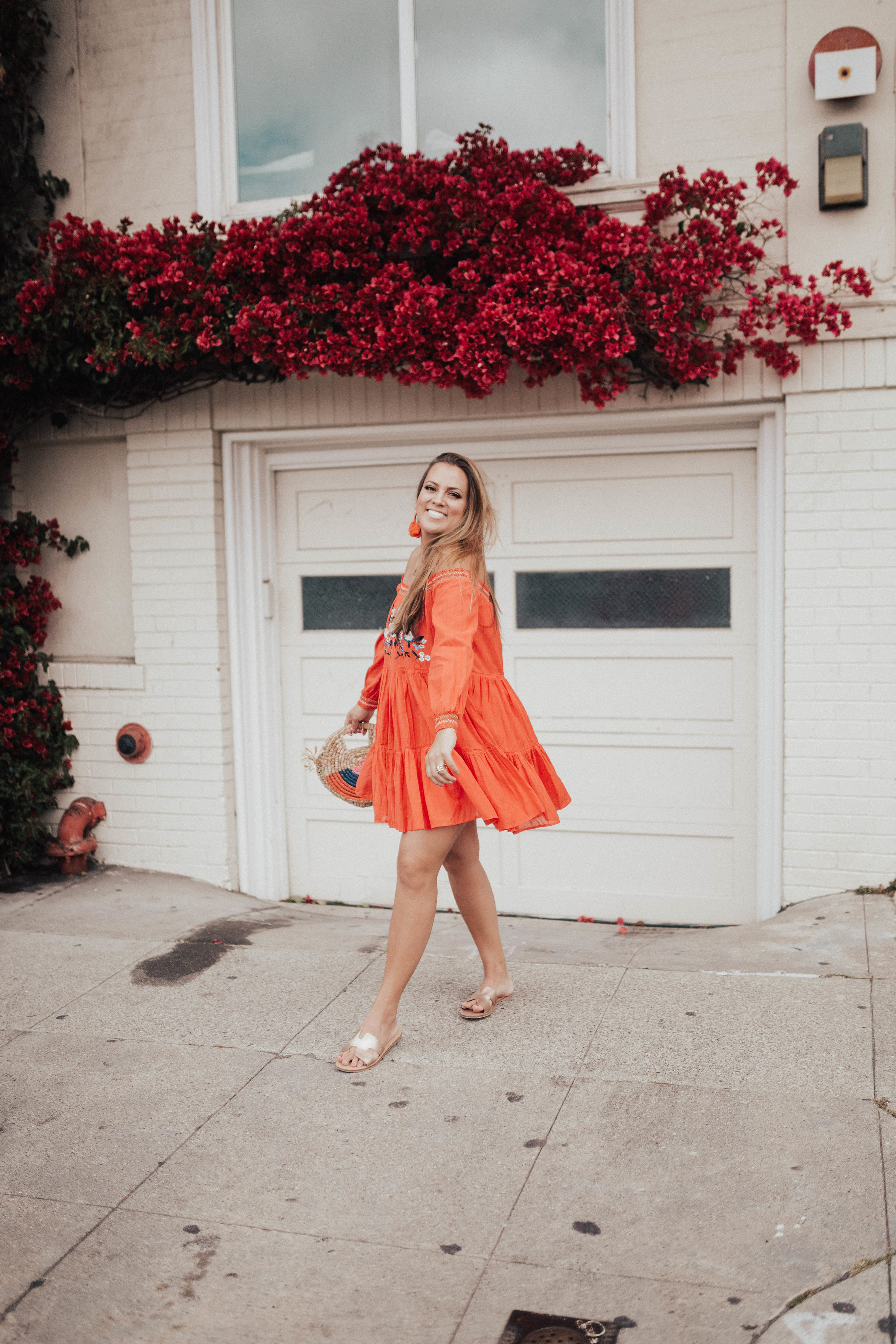 Ashley Zeal from Two Peas in a Prada wears an orange off the shoulder Free People dress and shares the best summer dresses. 