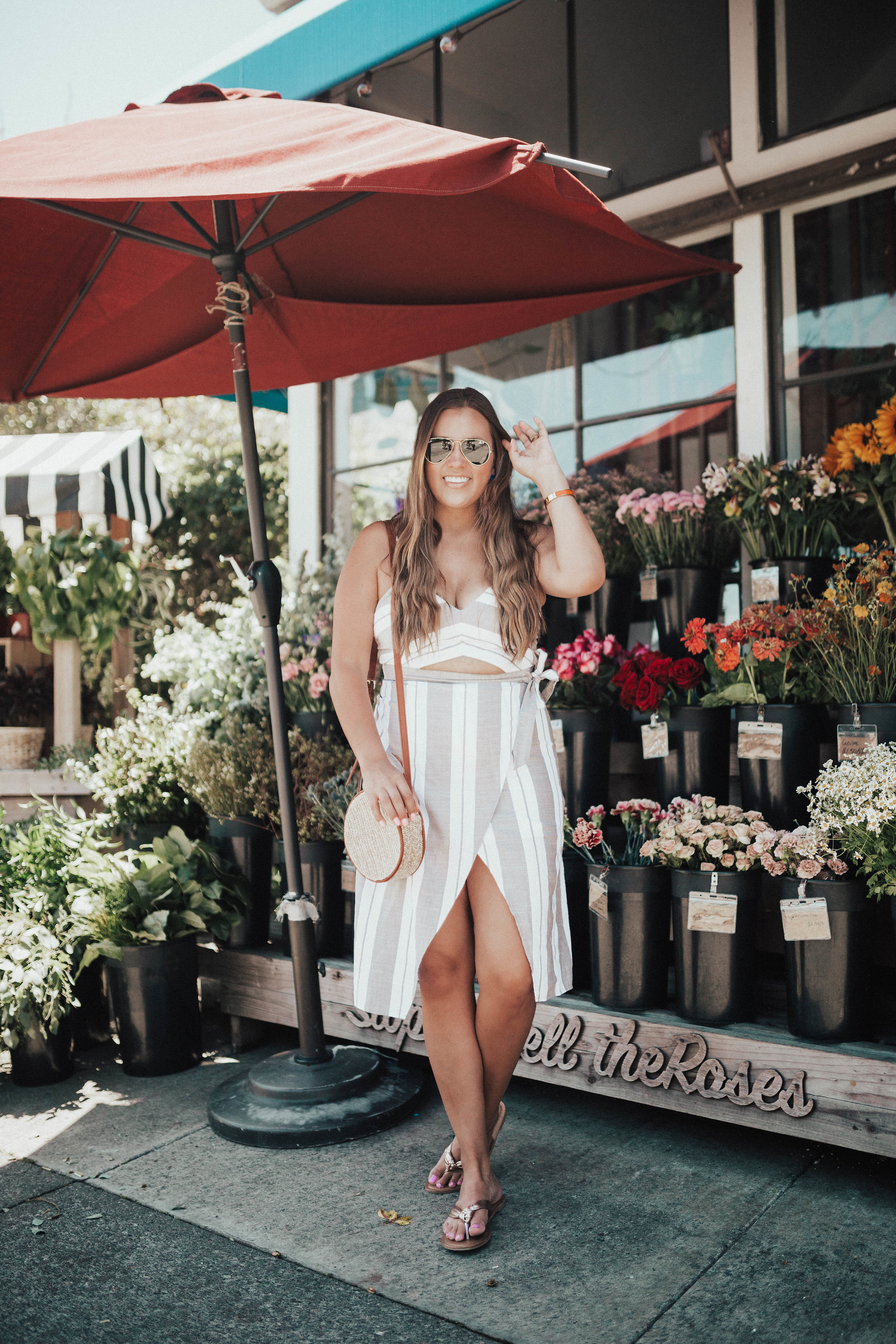 Ashley Zeal from Two Peas in a Prada shares the perfect dress for any body type. She is wearing the Striped Cut-Out Wrap Front Midi Dress from Express. 