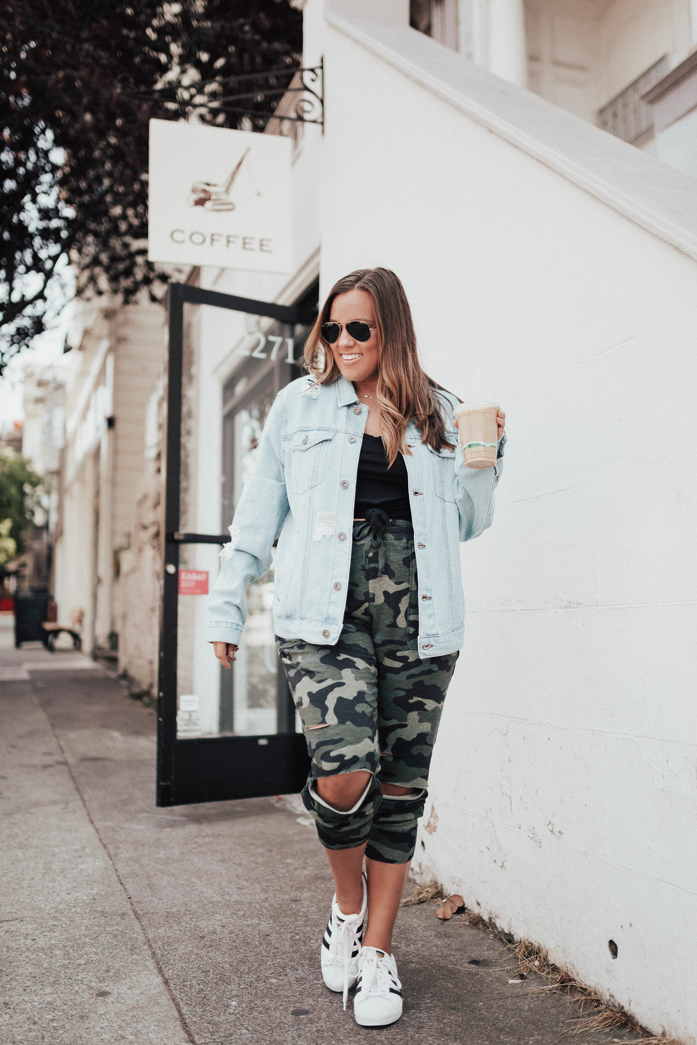 Ashley Zeal from Two Peas in a Prada shares three ways to wear camo. She is wearing a camo tank, camo joggers, and a drapey camo thermal. 