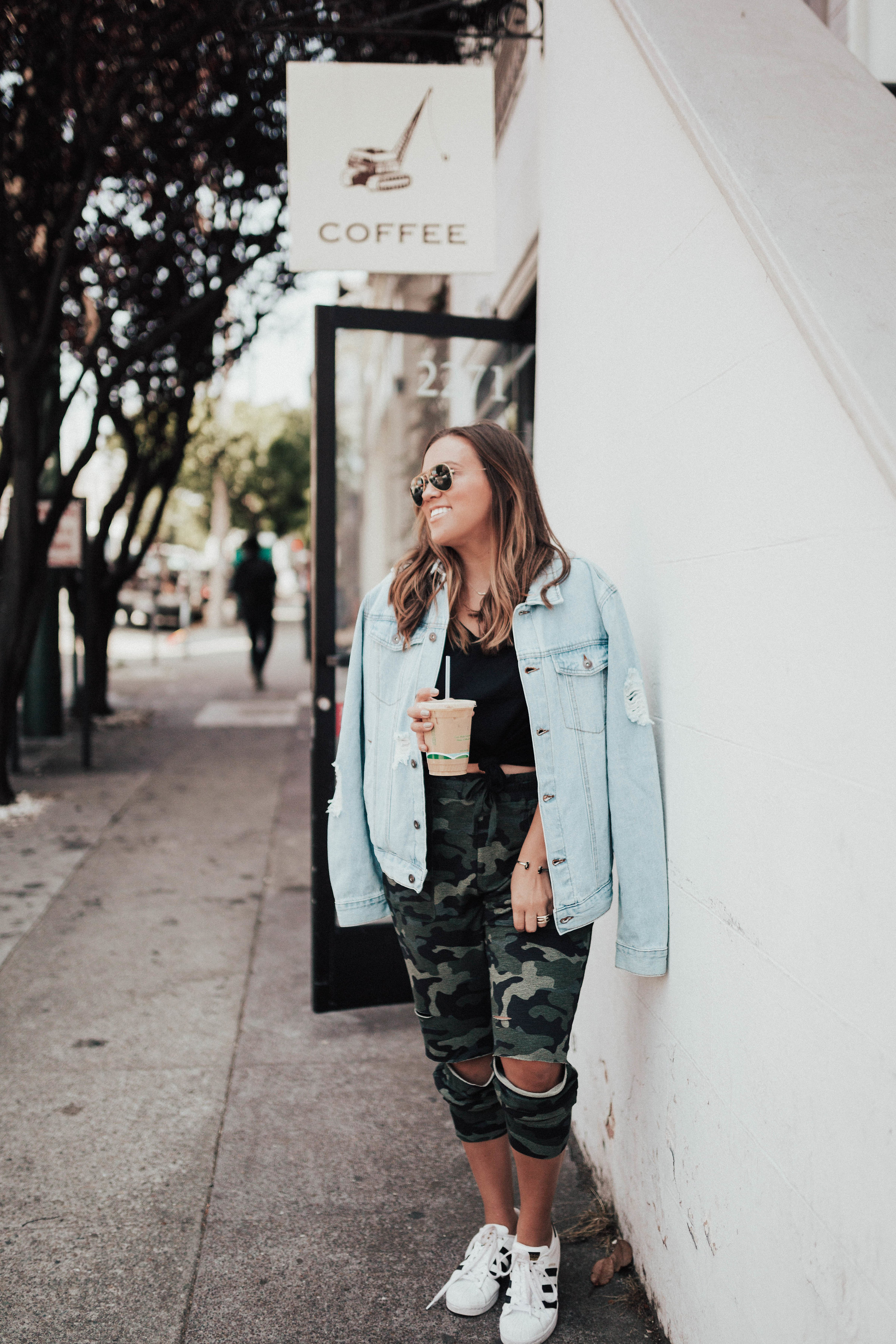Ashley Zeal from Two Peas in a Prada shares three ways to wear camo. She is wearing a camo tank, camo joggers, and a drapey camo thermal. 