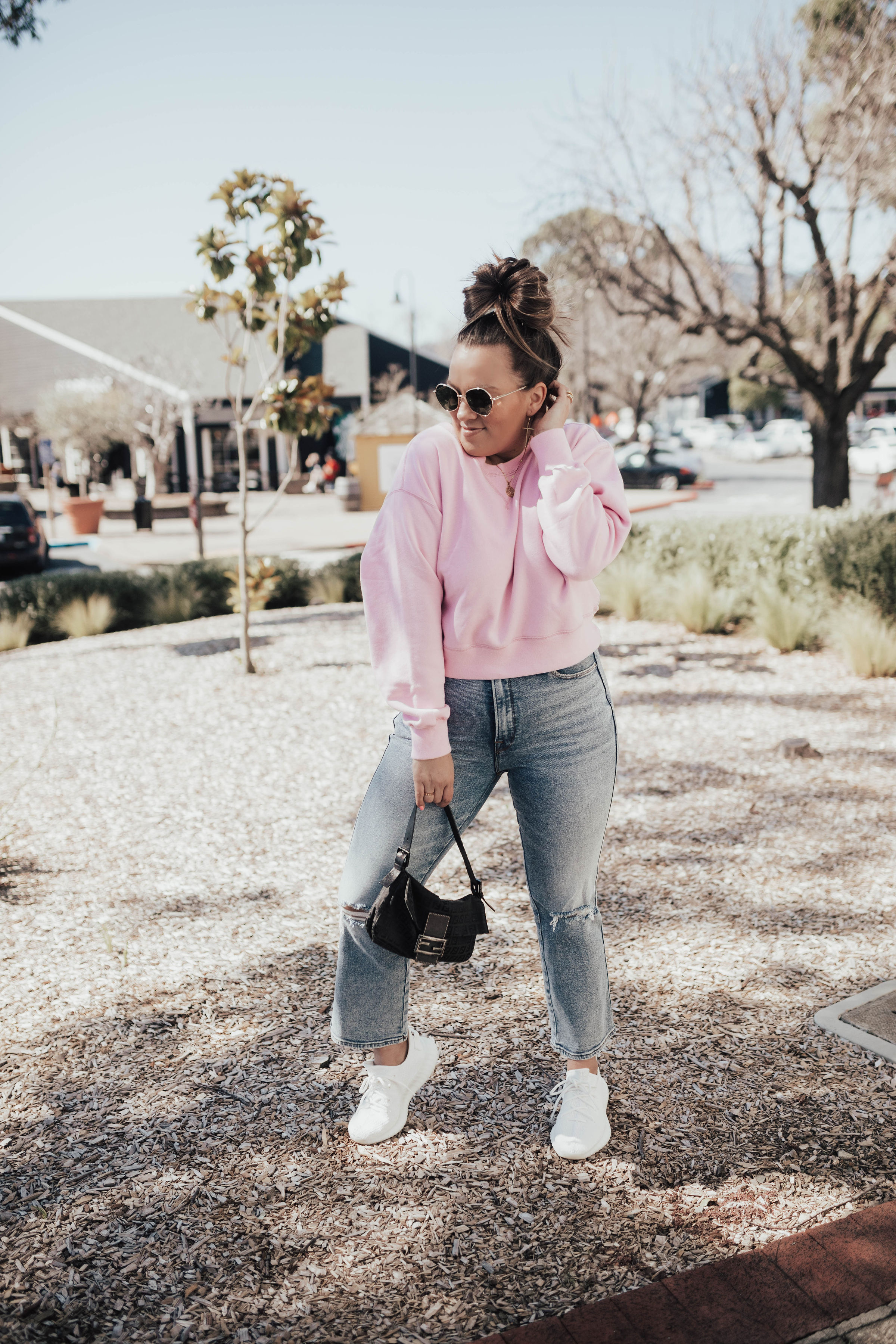 Ashley Zeal from the San Francisco blog, Two Peas in a Prada shares a pink Abercrombie sweatshirt. She is also wearing Good American jeans and Yeezy Triple Whites. 