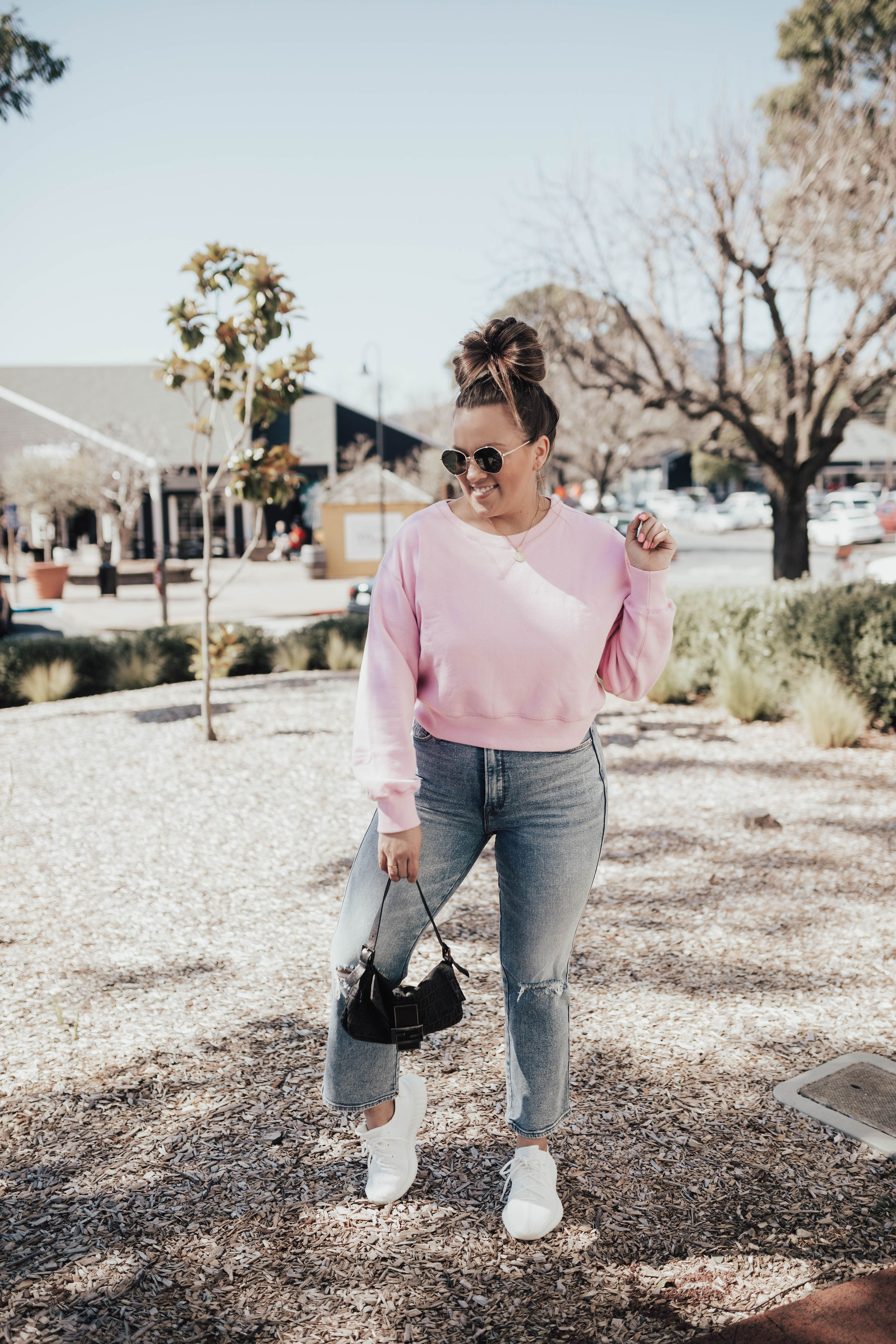Ashley Zeal from the San Francisco blog, Two Peas in a Prada shares a pink Abercrombie sweatshirt. She is also wearing Good American jeans and Yeezy Triple Whites. 